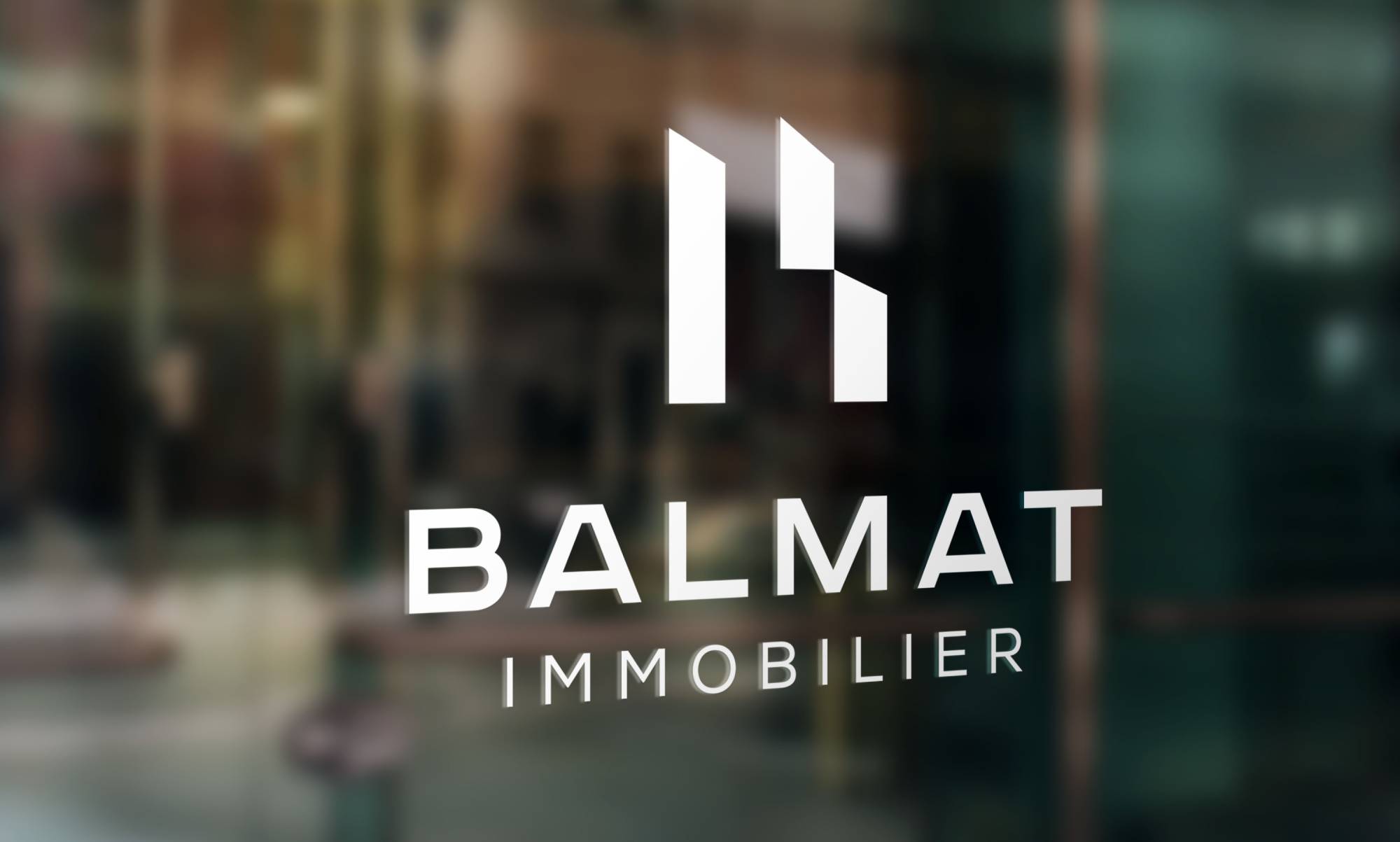 Logo Balmat Immobilier sur vitre de bureau